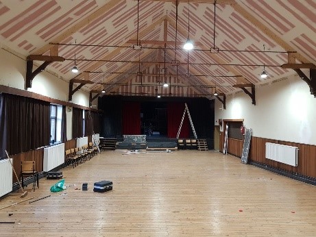 Een groot overzicht van de feestzaal met zicht op een publiek ruimte en een podium